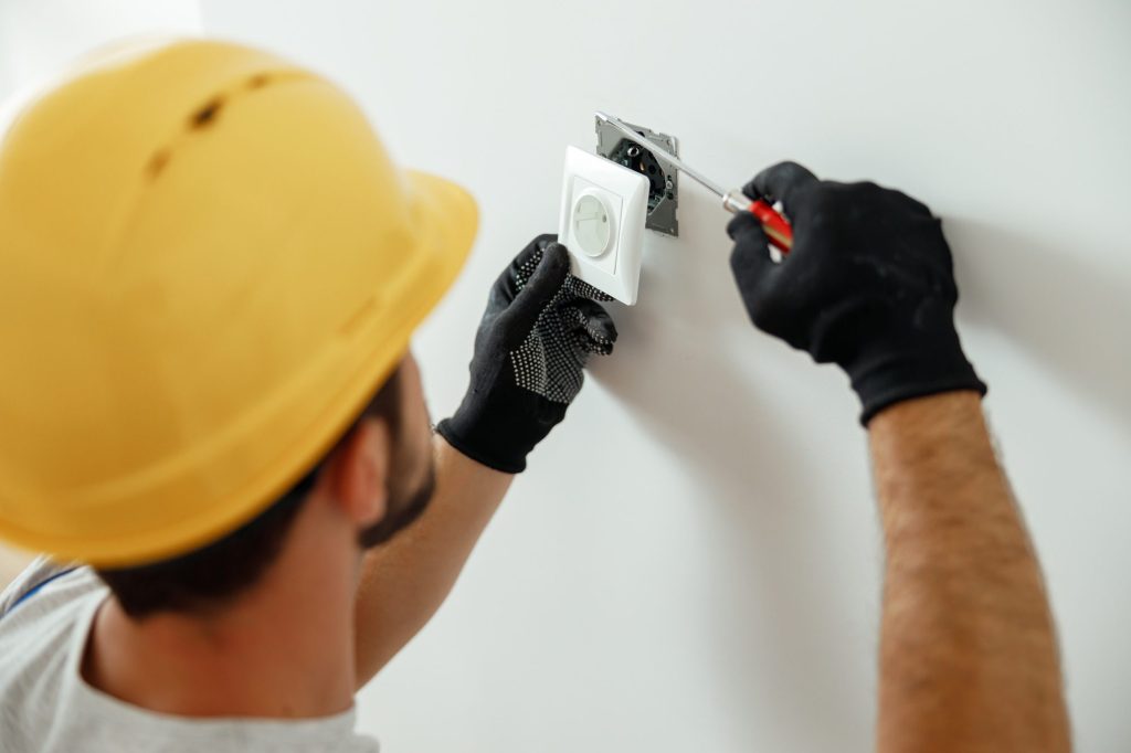 professional-electrician-in-uniform-using-screwdriver-while-installing-electrical-socket-outlet.jpg